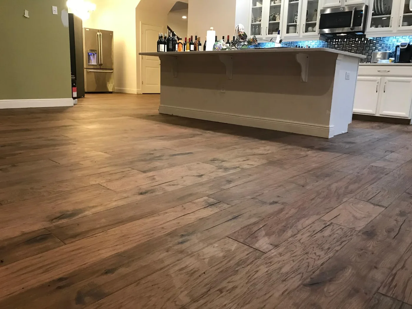 Completed hardwood flooring installation in an Orlando kitchen and living area
